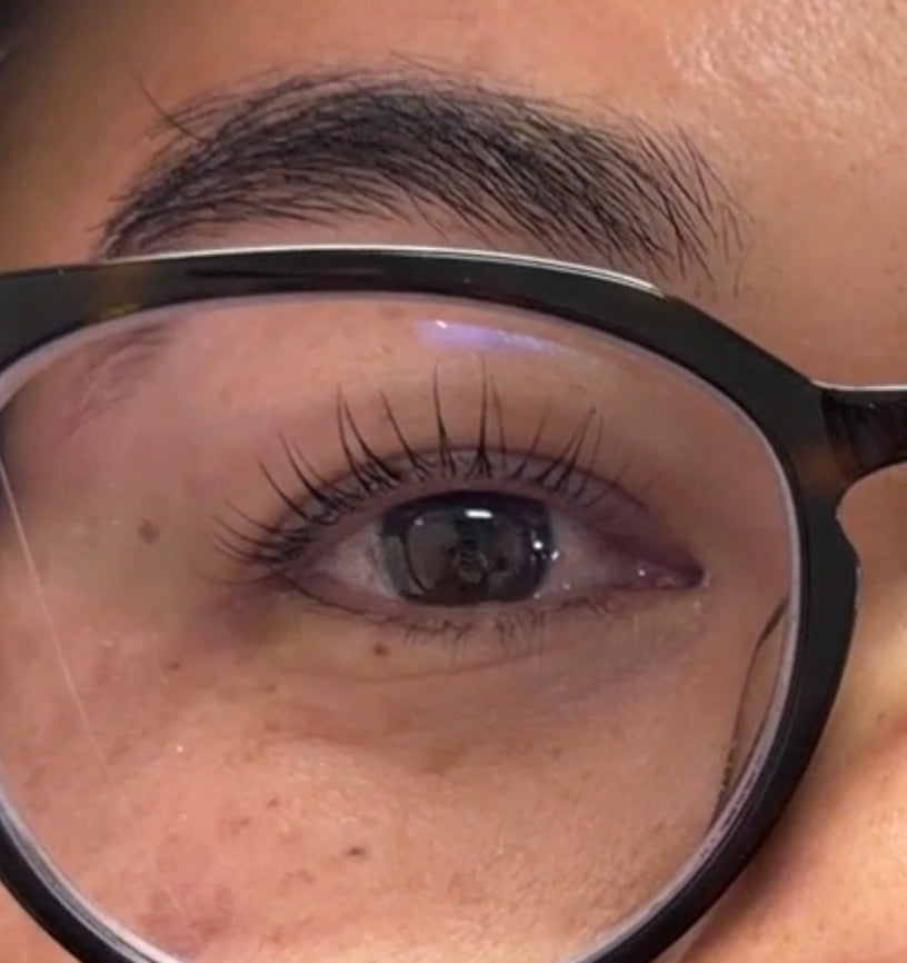 Korean lash lift result with Lifted Lounge Perm Solution – beautifully lifted lashes on client wearing glasses